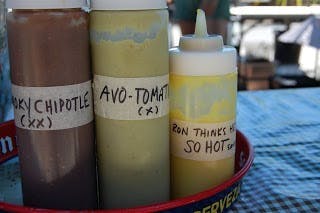 three bottles of chipotle, avo tomato, and a yellow sauce
