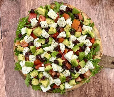 a pizza sitting on top of a wooden cutting board