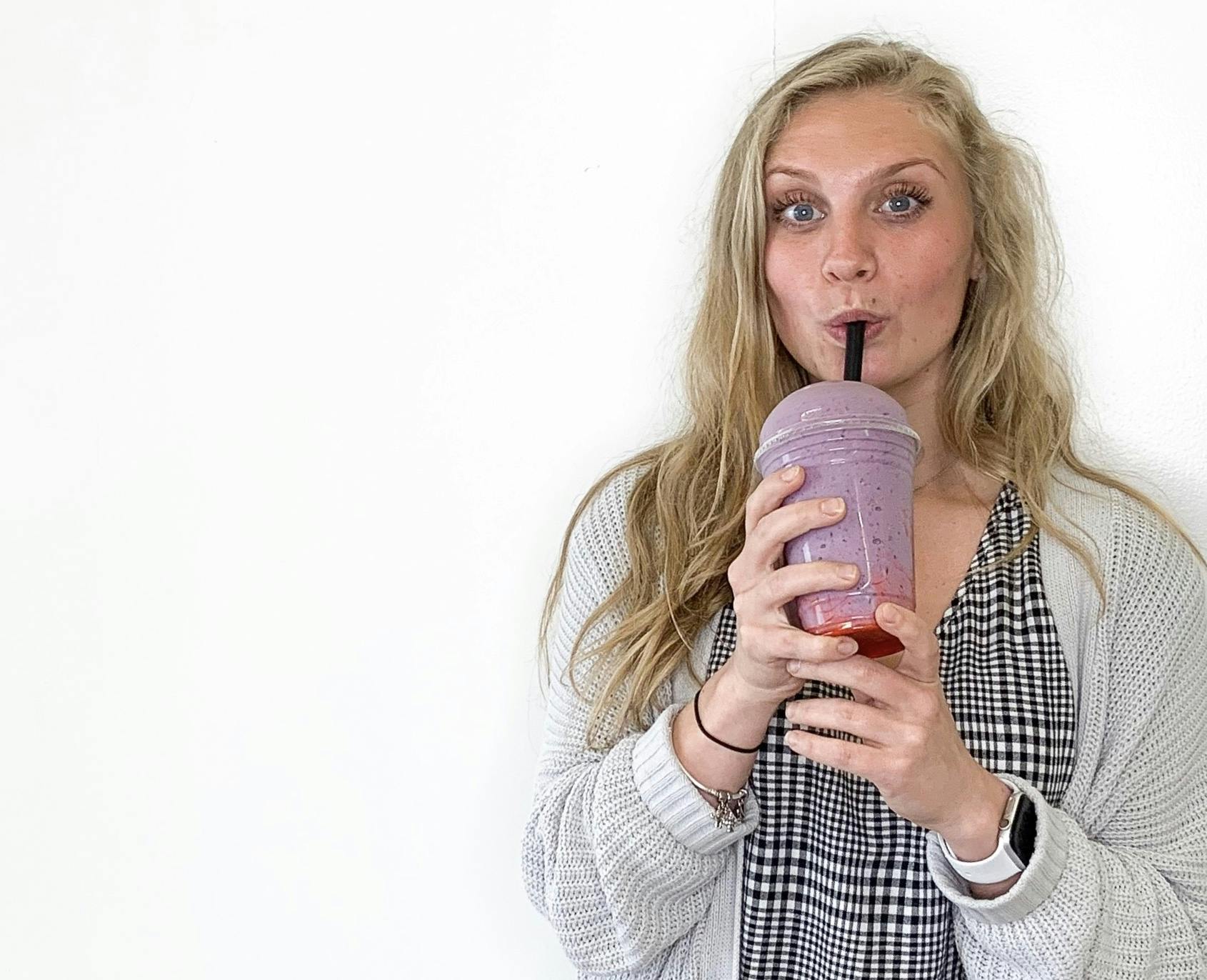 a woman posing with a smoothie for the camera