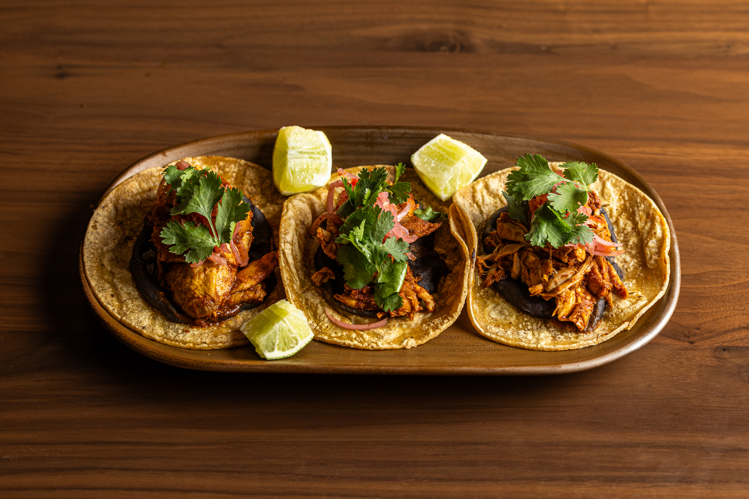 a plate of tacos with meat and cilantro