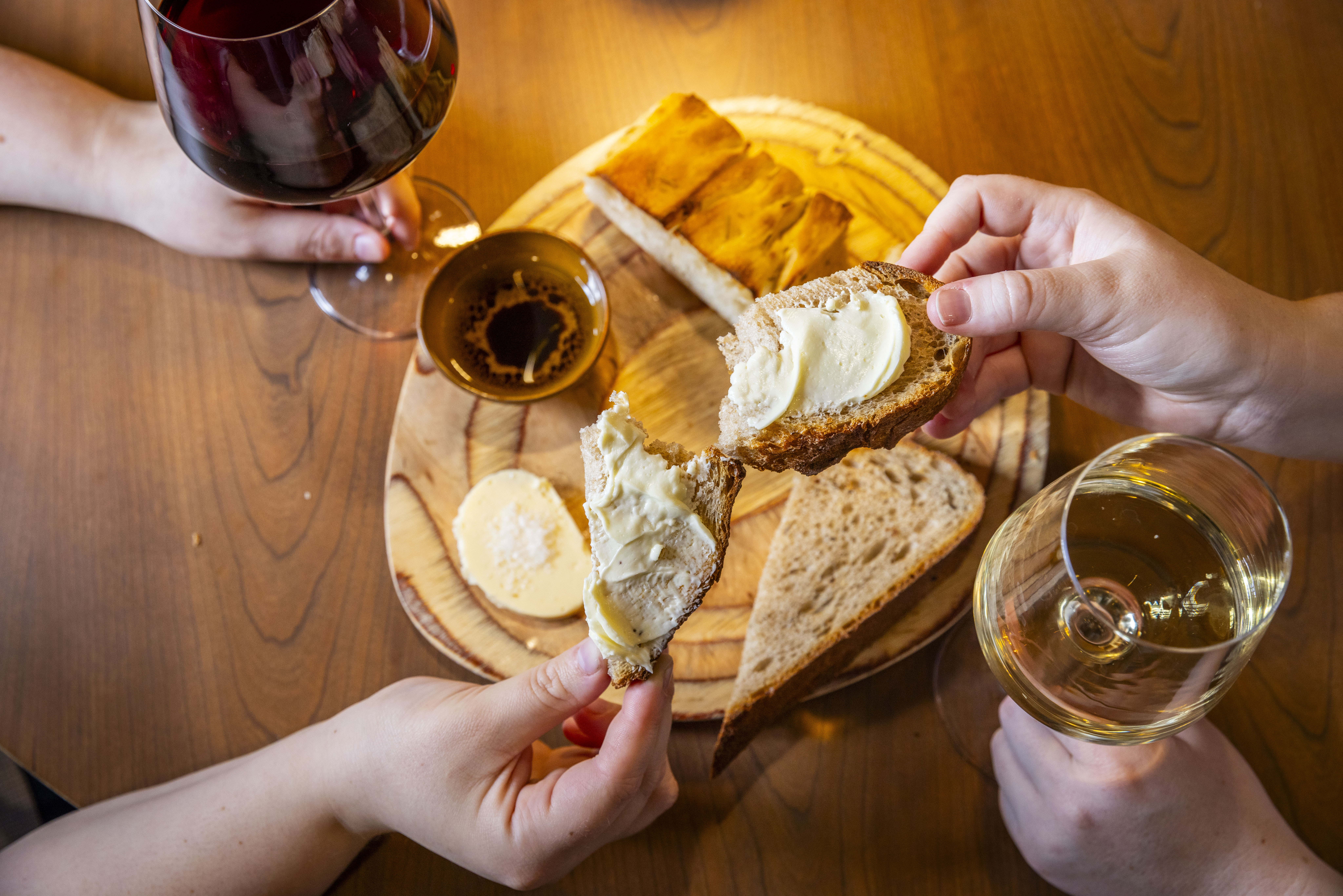 a group of people eating bread with butter