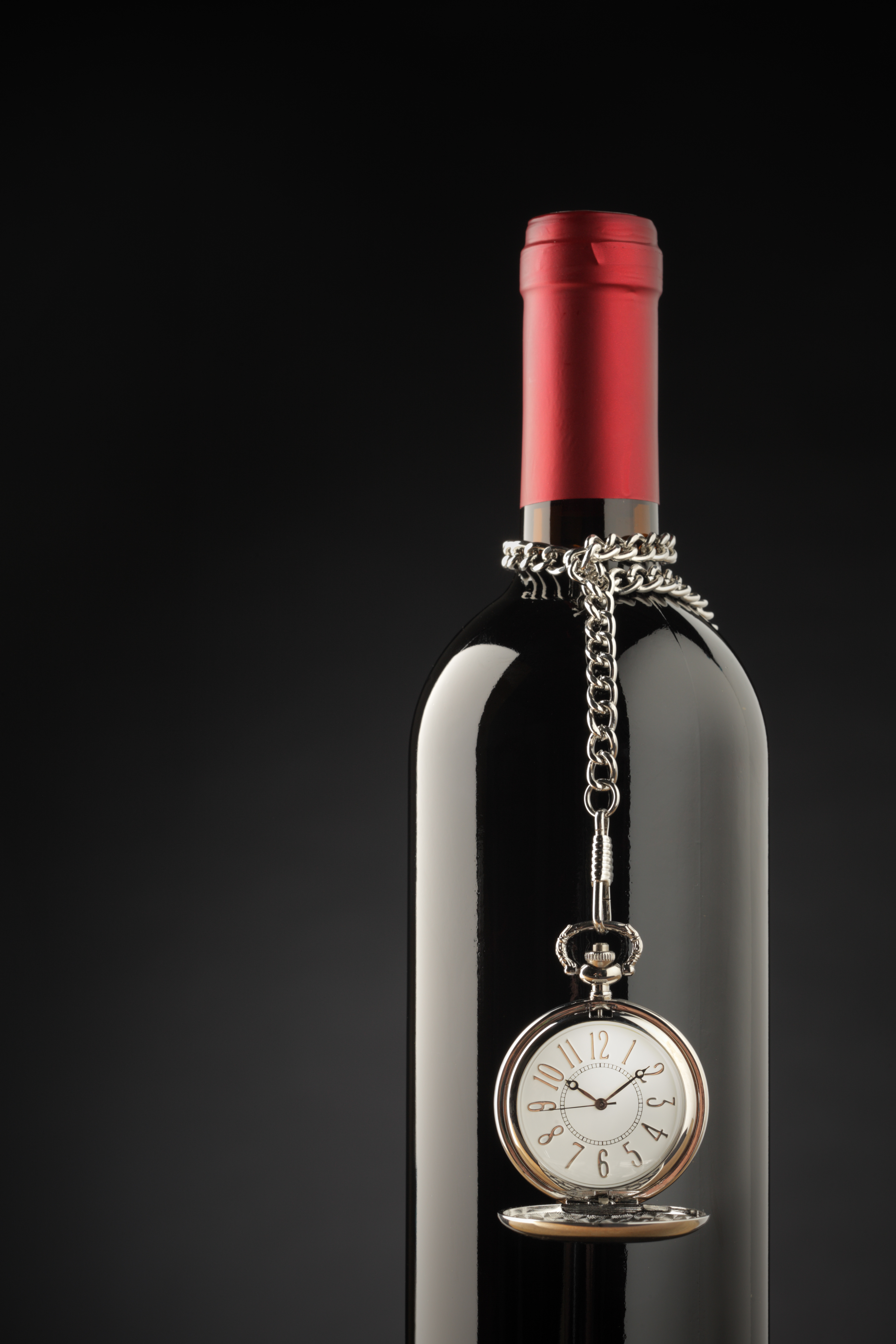 a bottle of wine with a chain and a watch