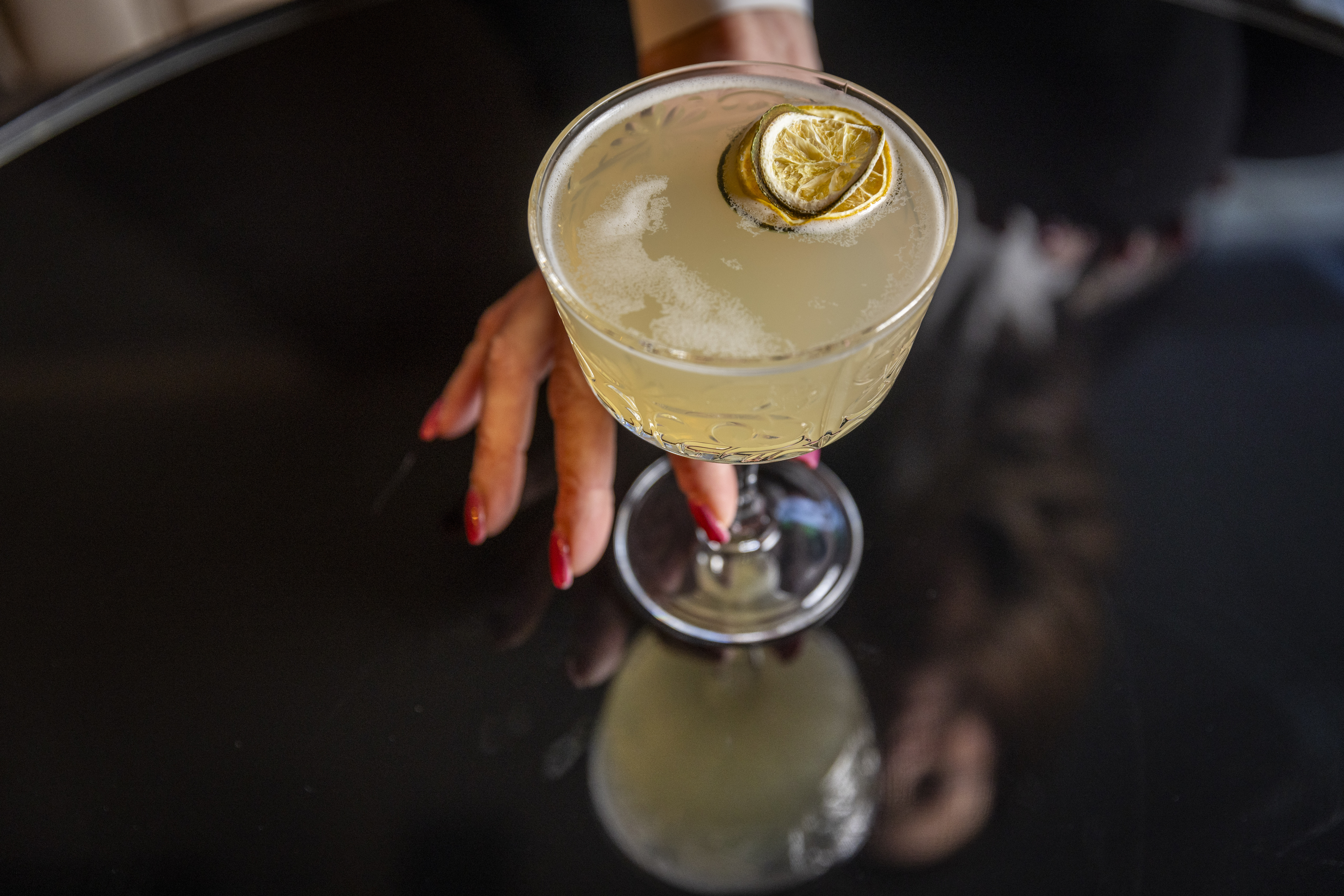 a hand holding a glass of drink
