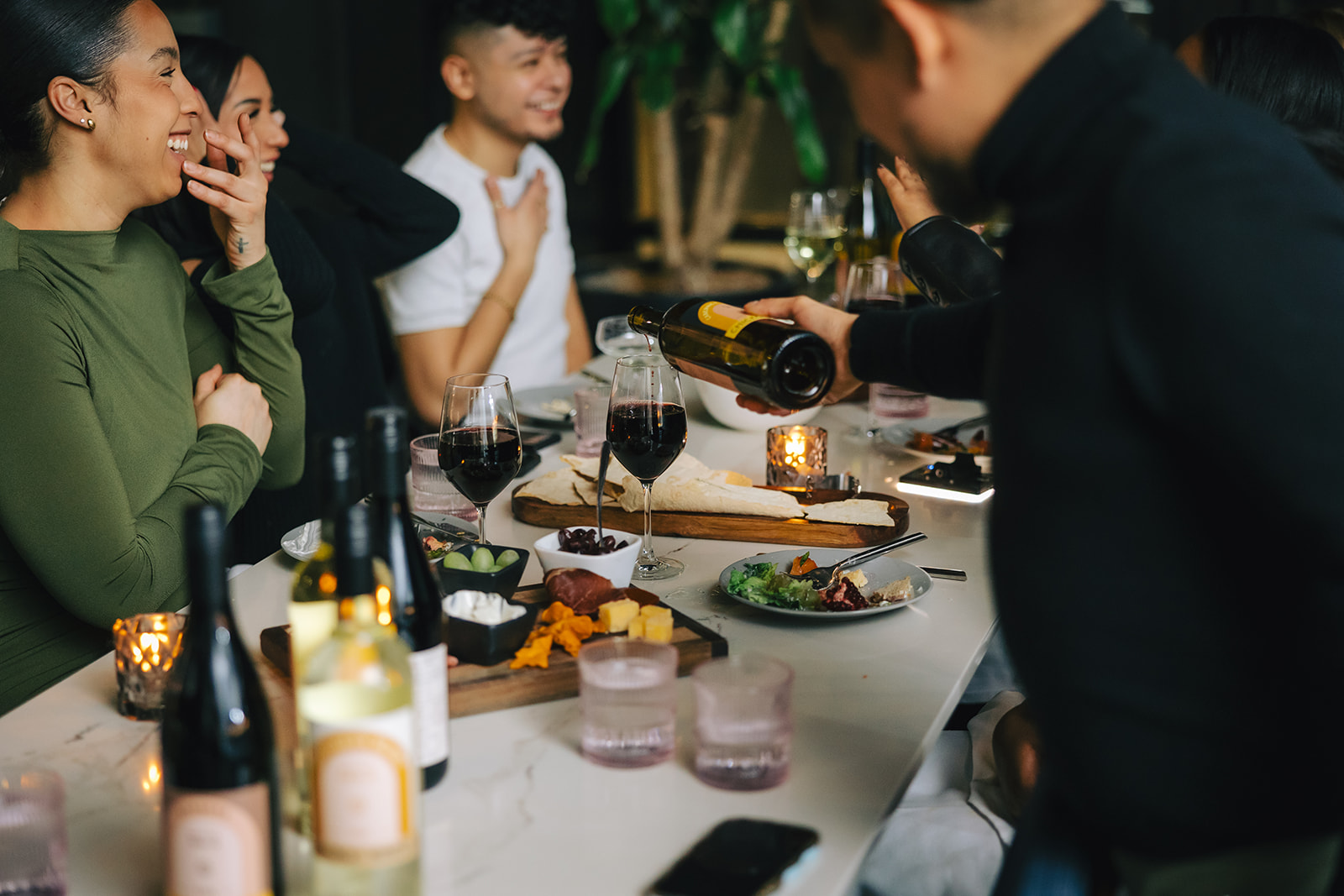 a group of people sitting at a table drinking wine