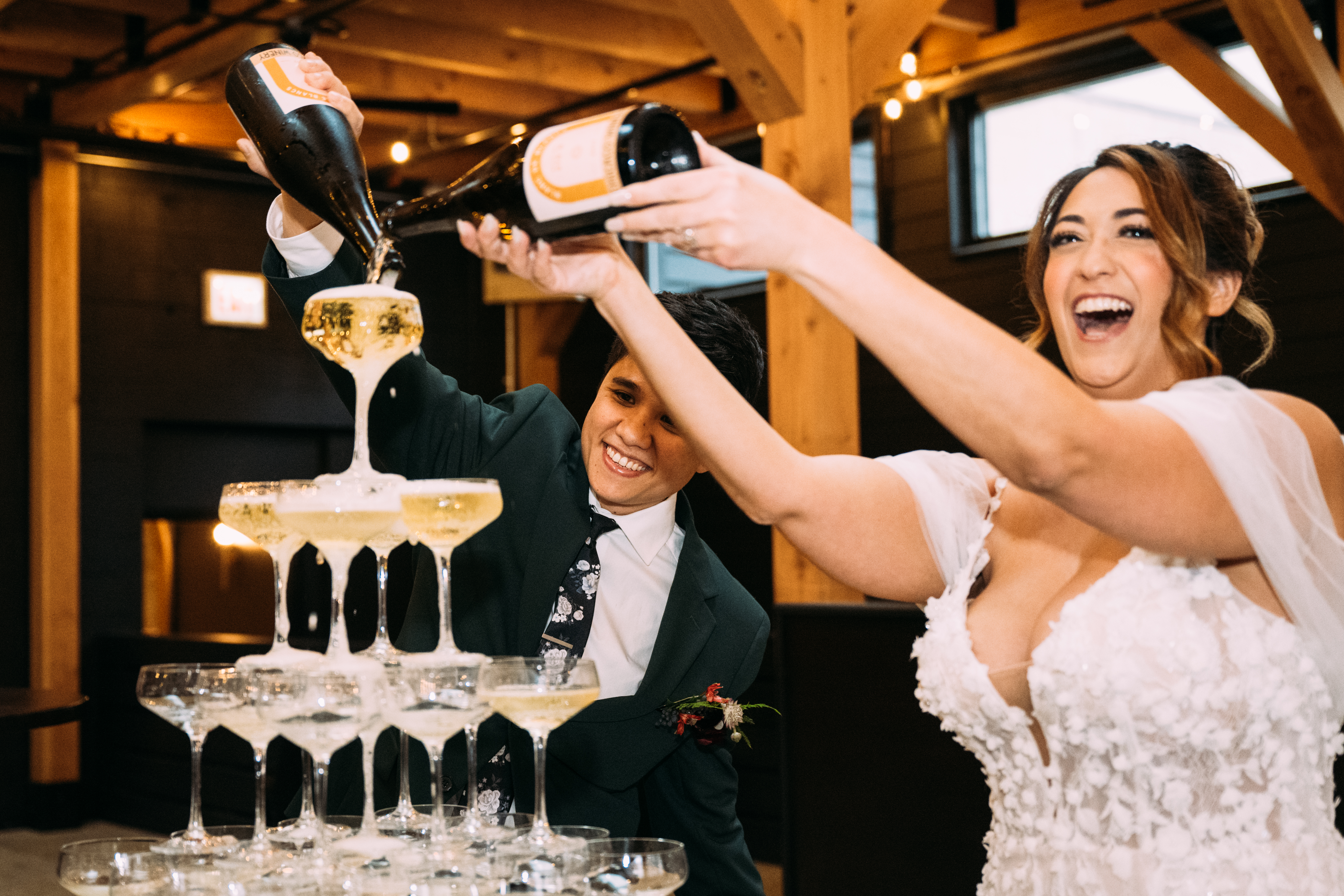 A couple pouring sparkling wine over a tower included in the all inclusive wedding venue..