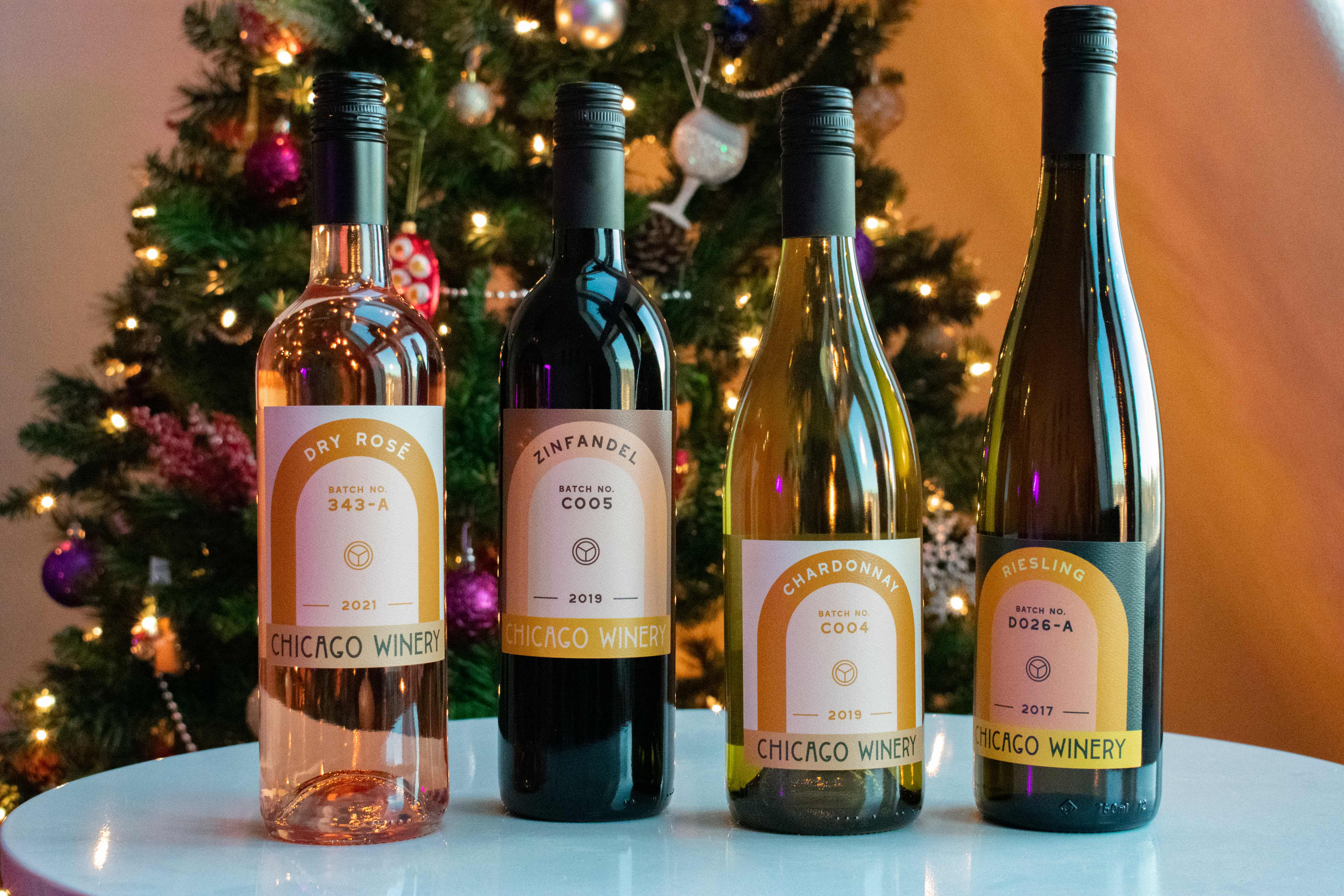 bottles of wine in front of a christmas tree 