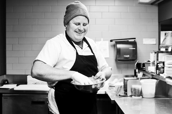 a person standing in a kitchen preparing food