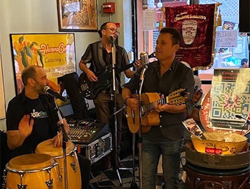 Musicians singing and playing instruments at our Chelsea live Latin music restaurant.