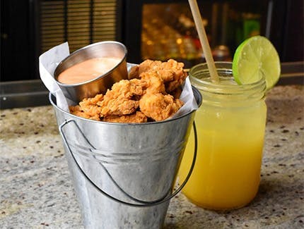 Chicharrones De Pollo, one of our New Cassel Happy Hour food specials, and a cocktail.