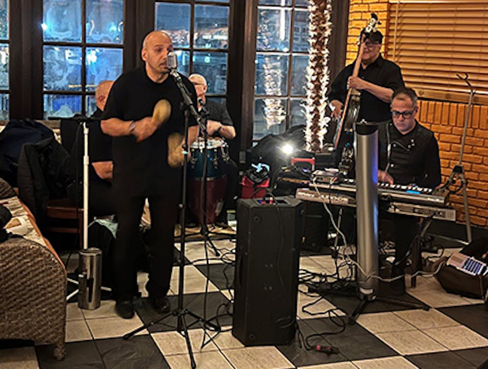 Musicians singing and playing instruments at our Menlo Park Mall, Edison live Latin music restaurant.