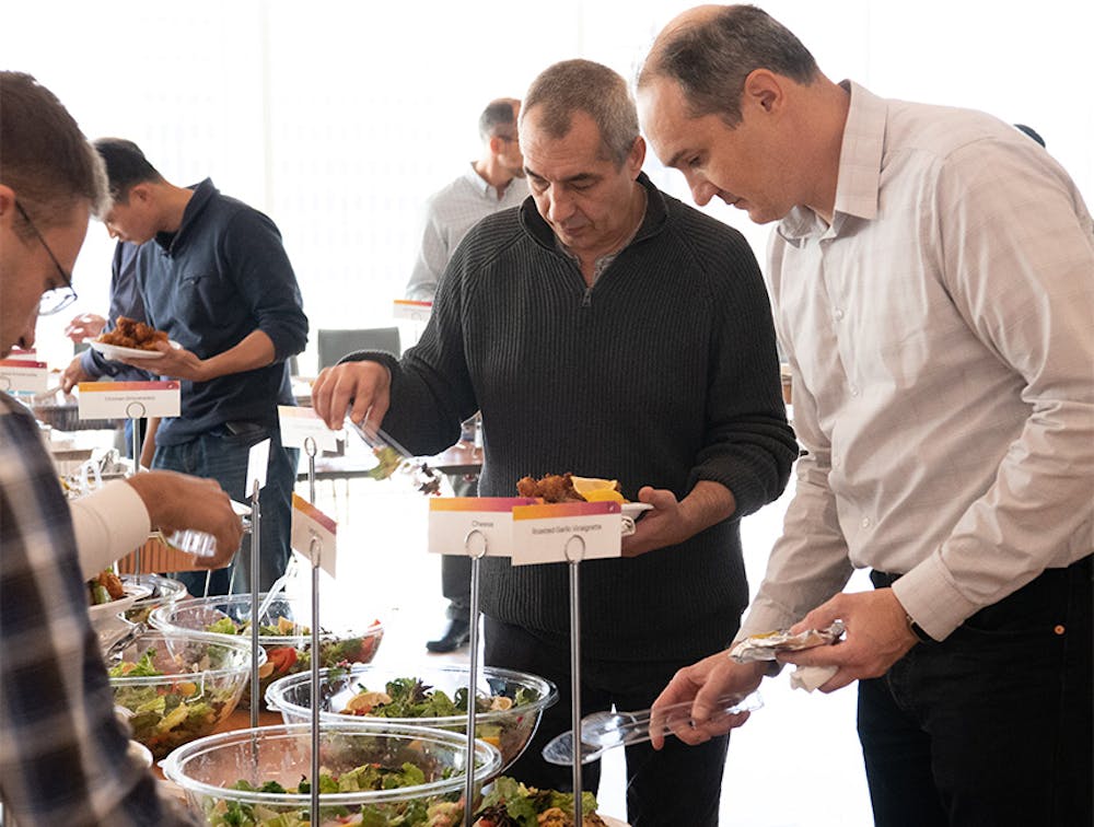 Male employees taking chicken and salads from our office party catering near Lenox Hill, Manhattan, NY.
