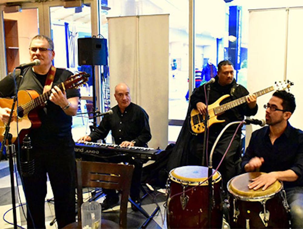 Musicians singing and playing instruments at our Williston Park live Latin music restaurant.