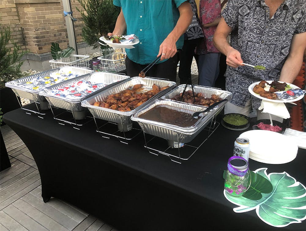 Employees taking chicken and beans from food trays provided by our Lenox Hill, Manhattan company event caterers.