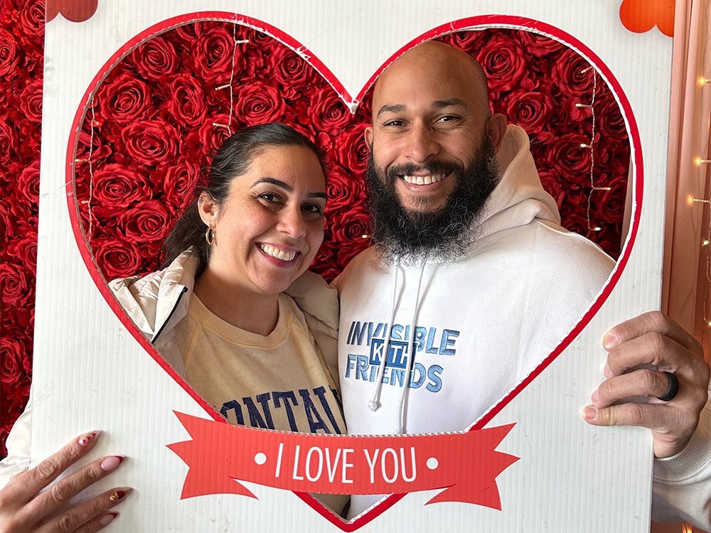 Man and woman posing for a photo behind a heart-shaped cutout at our event venue near Edison, New Jersey.