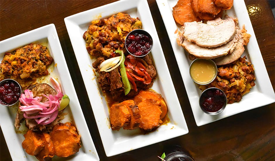 Three plates with meat, stuffing, and potatoes, our options for Kips Bay, Manhattan Thanksgiving restaurant dining.