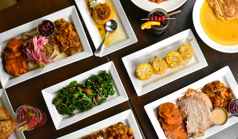 A dining table covered with multiple plates and drinks at Havana Central, one of the top Thanksgiving restaurants near SoHo, Manhattan, New York.