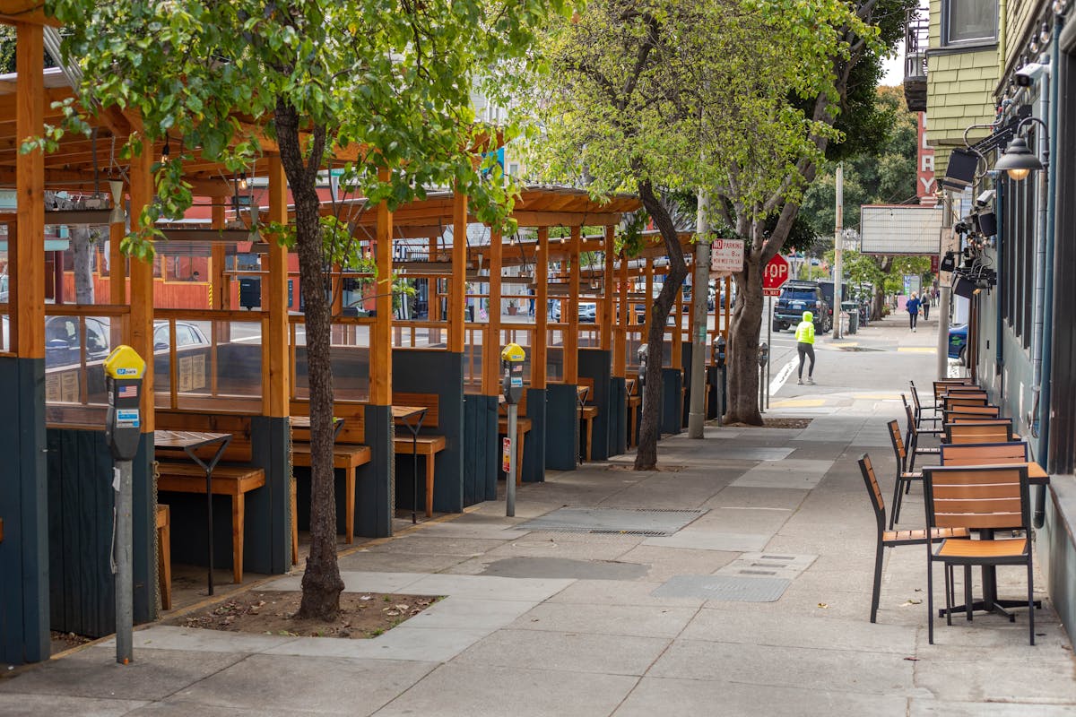 a wooden bench on the side of the street