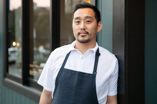 a man standing in front of a window posing for the camera