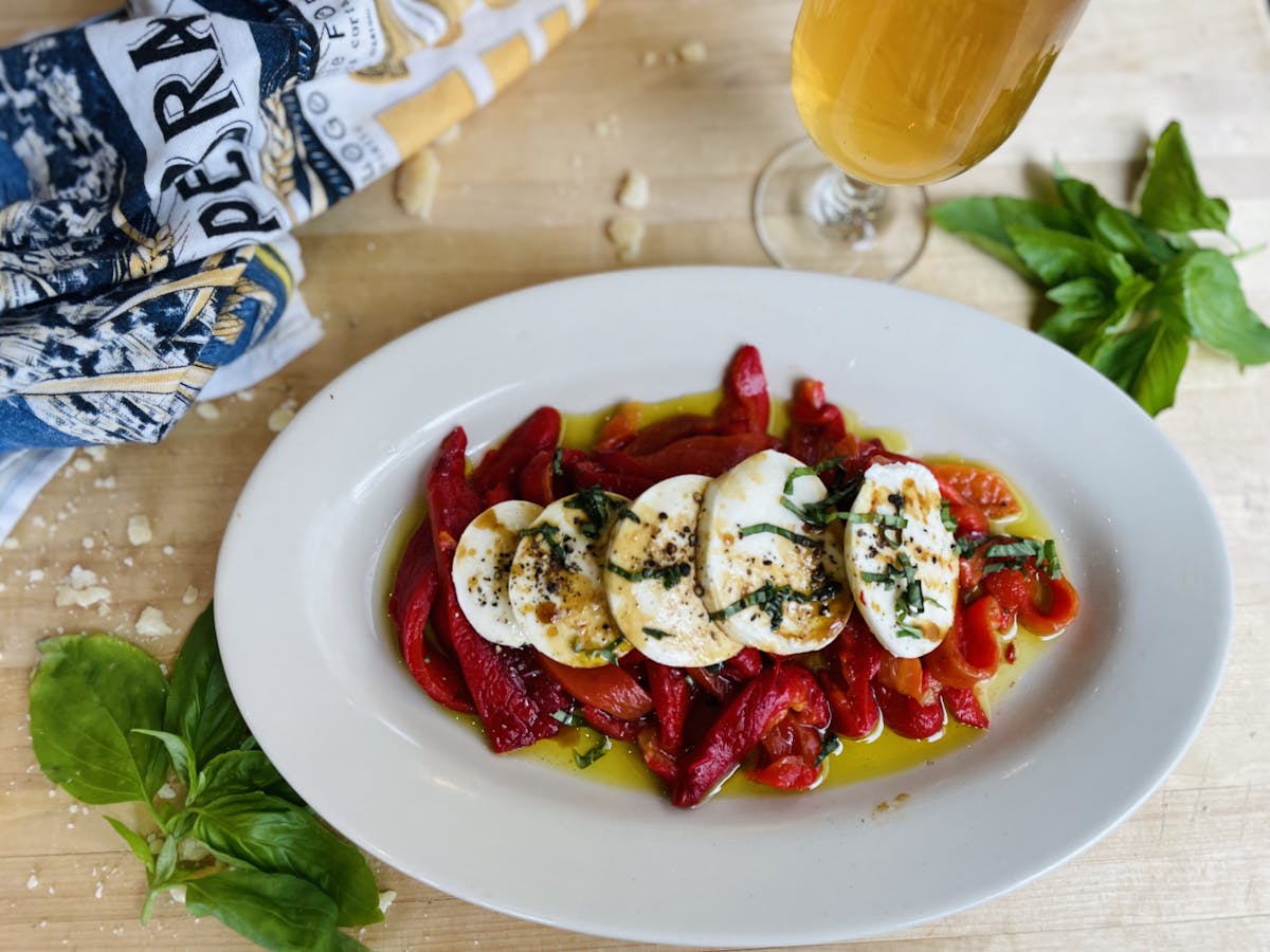 roasted red peppers on a platter with buffalo mozzarella, basil, balsalmin, olive oil