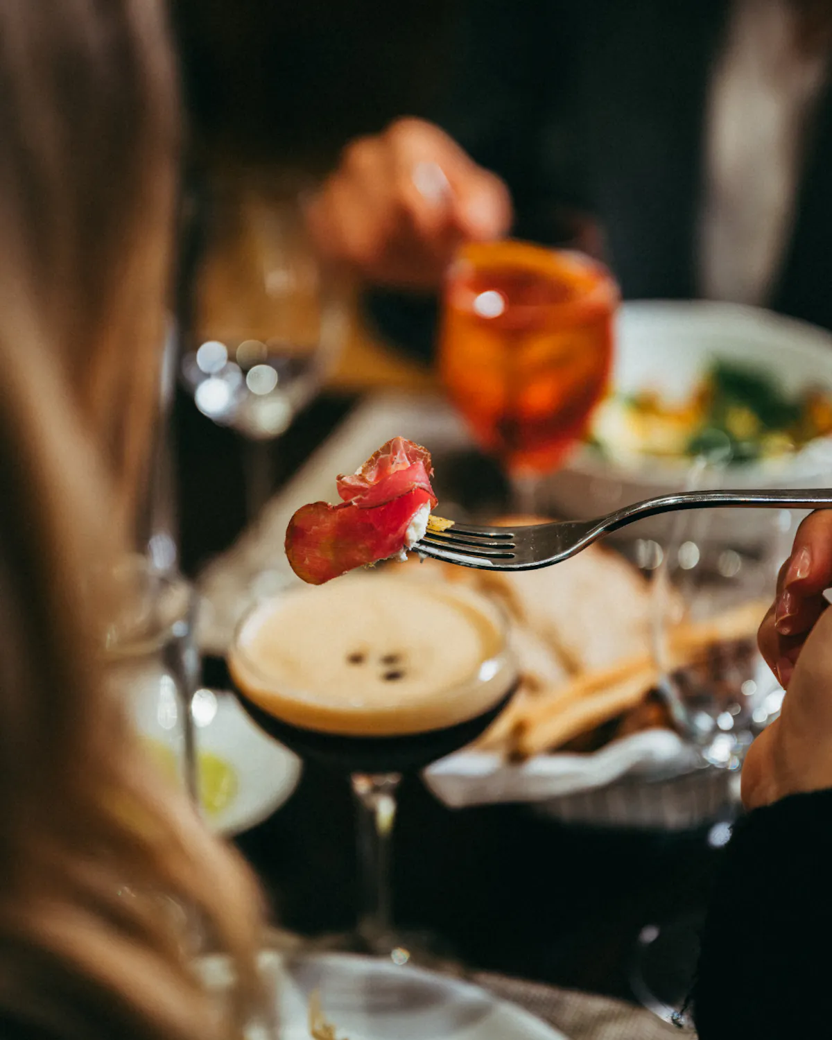 a person sitting at a table with wine glasses