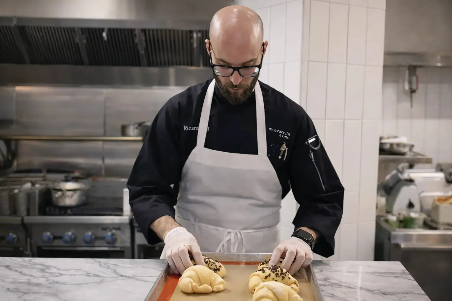 Pastry Chef standing in a kitchen preparing fresh Cornetti