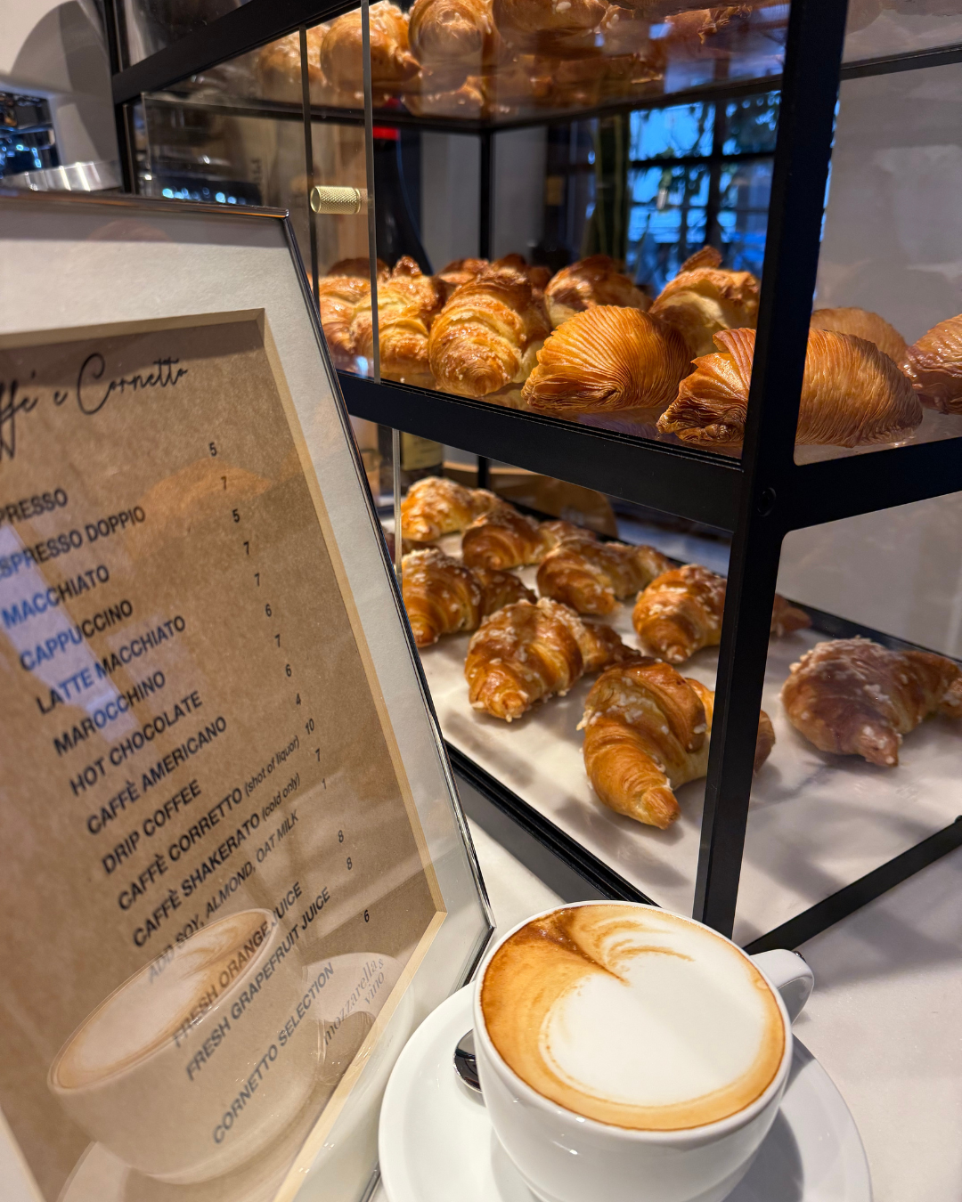 a cup of coffee next to a glass display case