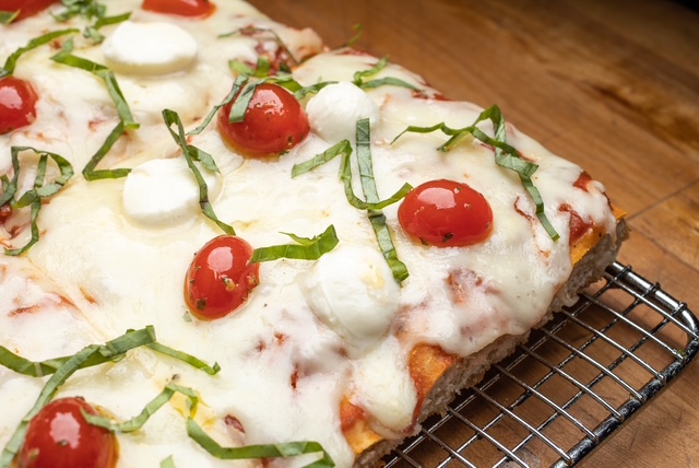 a pizza sitting on top of a wooden cutting board