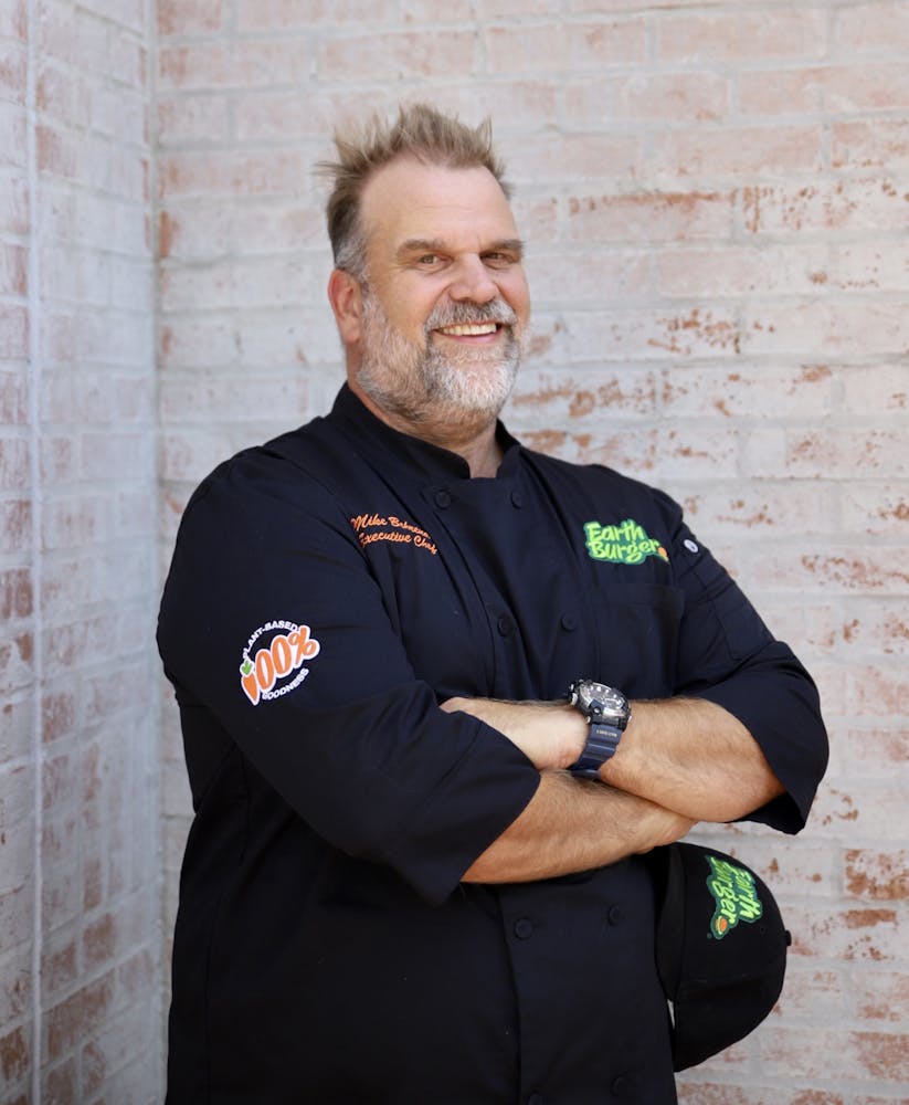 a man standing next to a brick wall