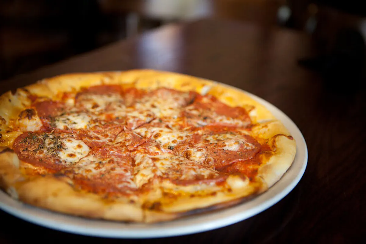 a pizza sitting on top of a wooden table