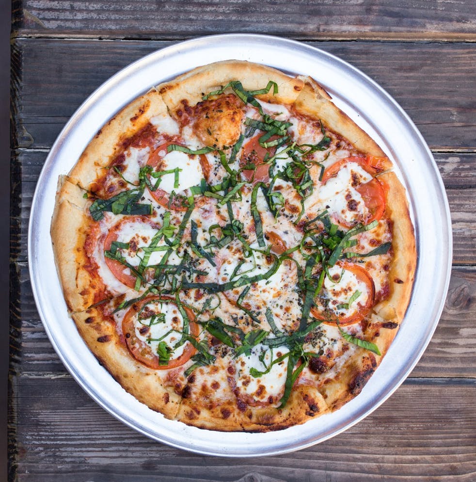 a pizza sitting on top of a wooden table