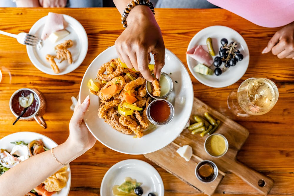 a person sitting at a table with a plate of food