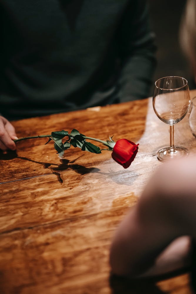a glass of wine sitting on top of a wooden cutting board