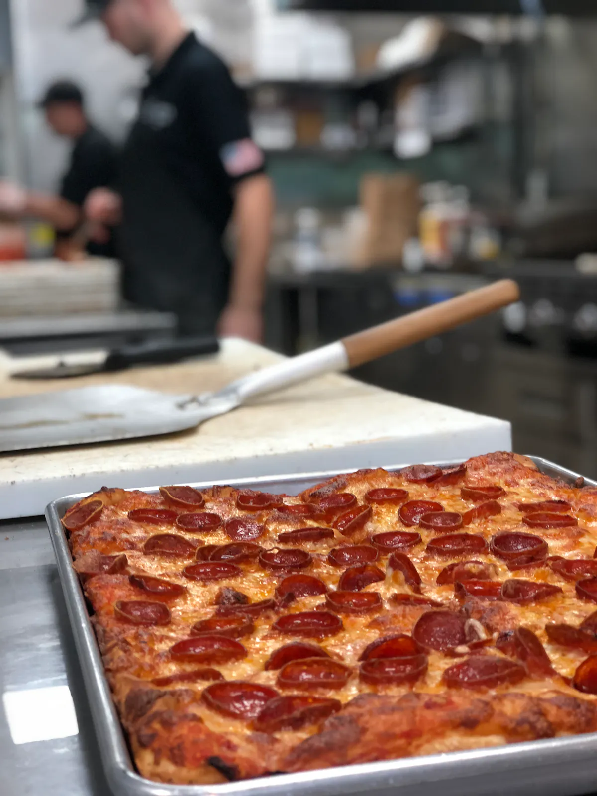 a large pepperoni pizza on a tray