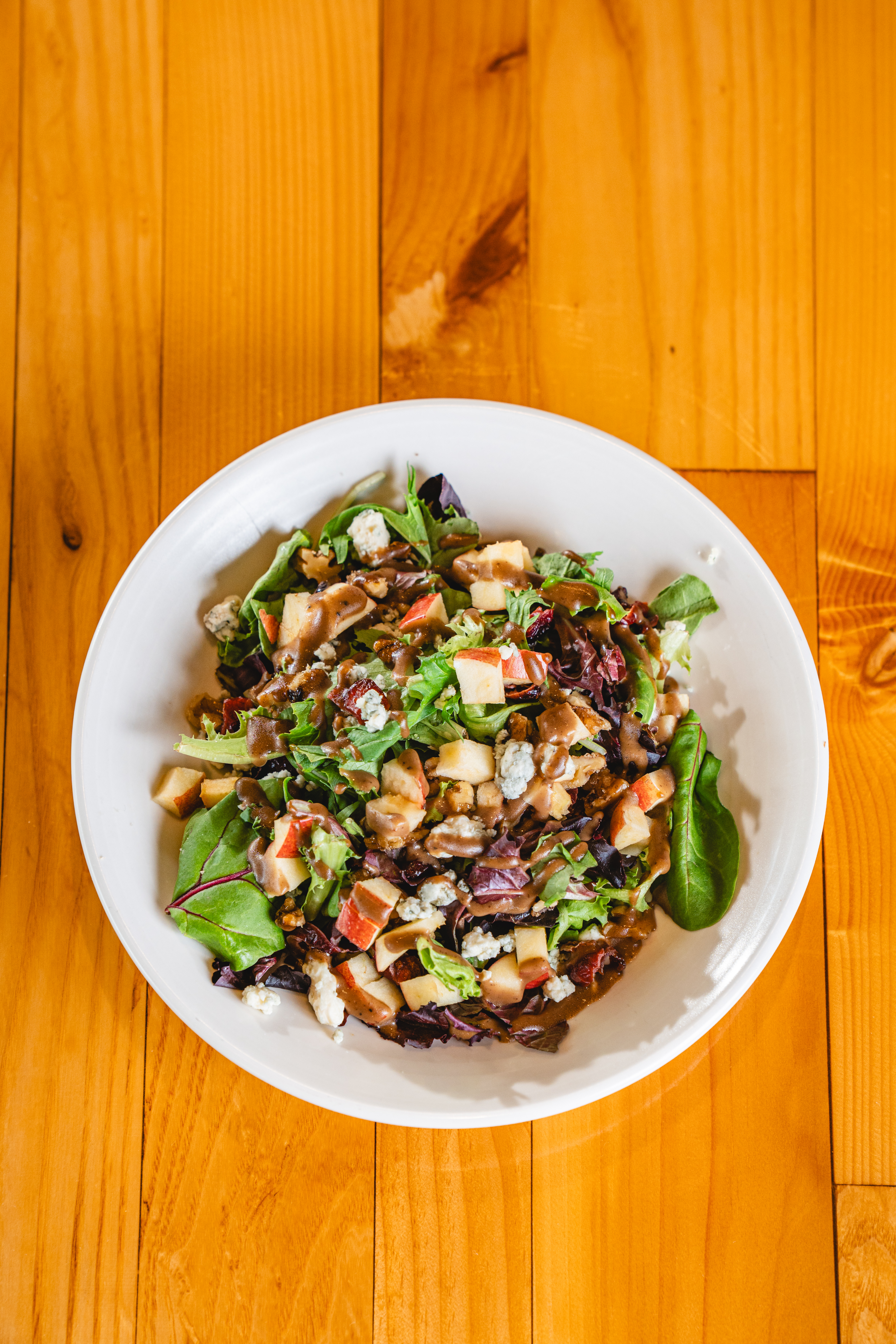 a bowl of food sitting on top of a wooden table