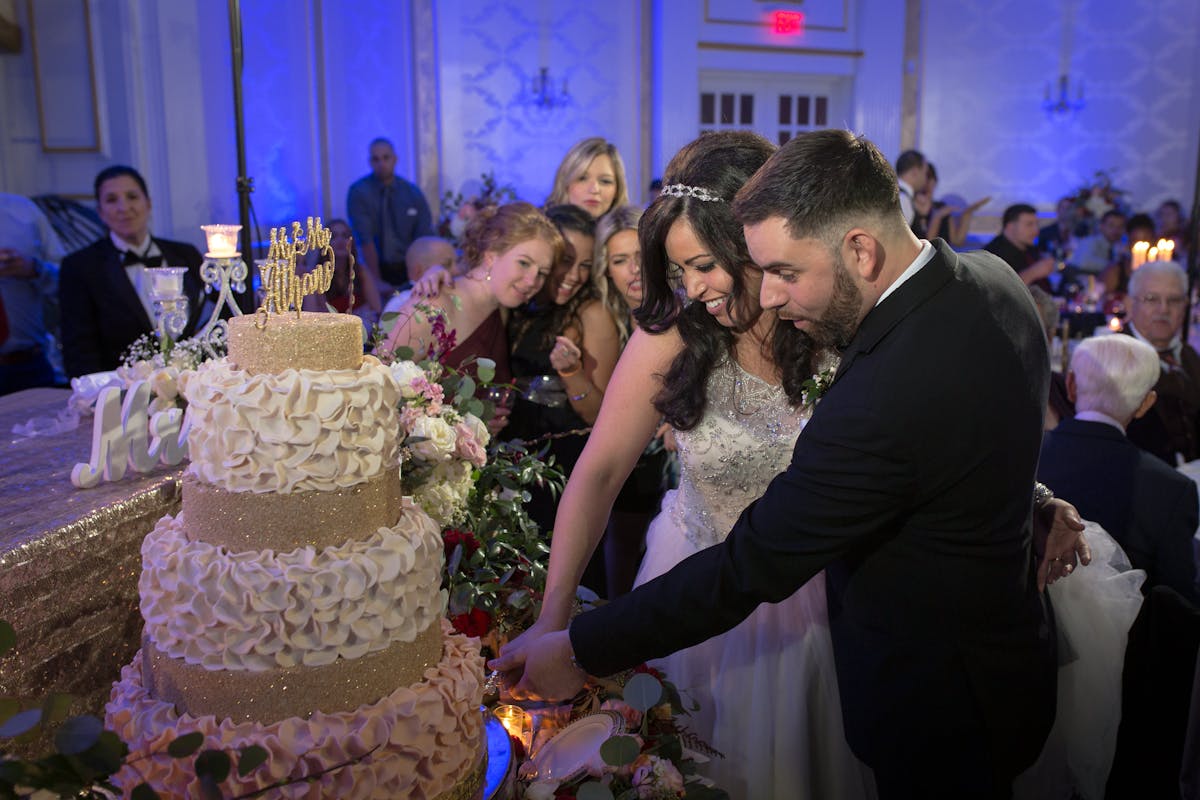 a man and woman cutting a wedding cake