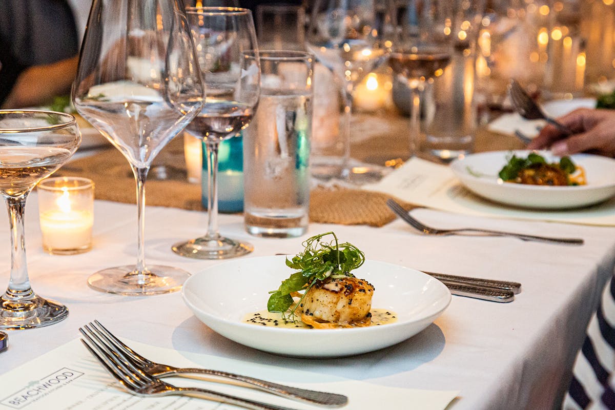 a plate of food and glasses of wine on a table