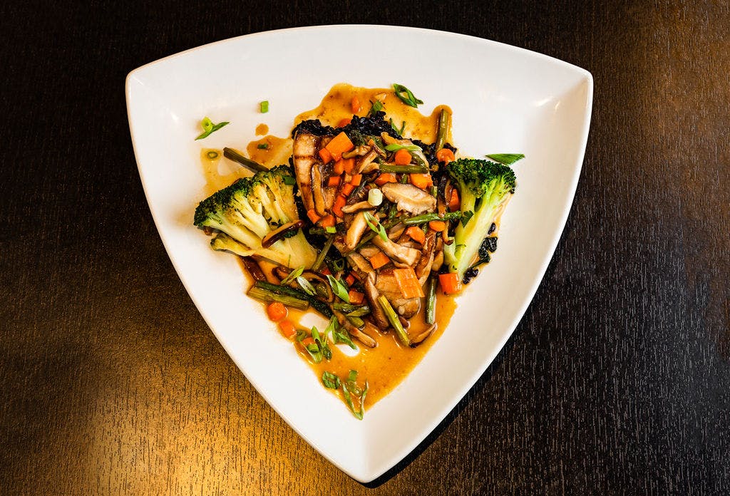 a white plate topped with meat and vegetables