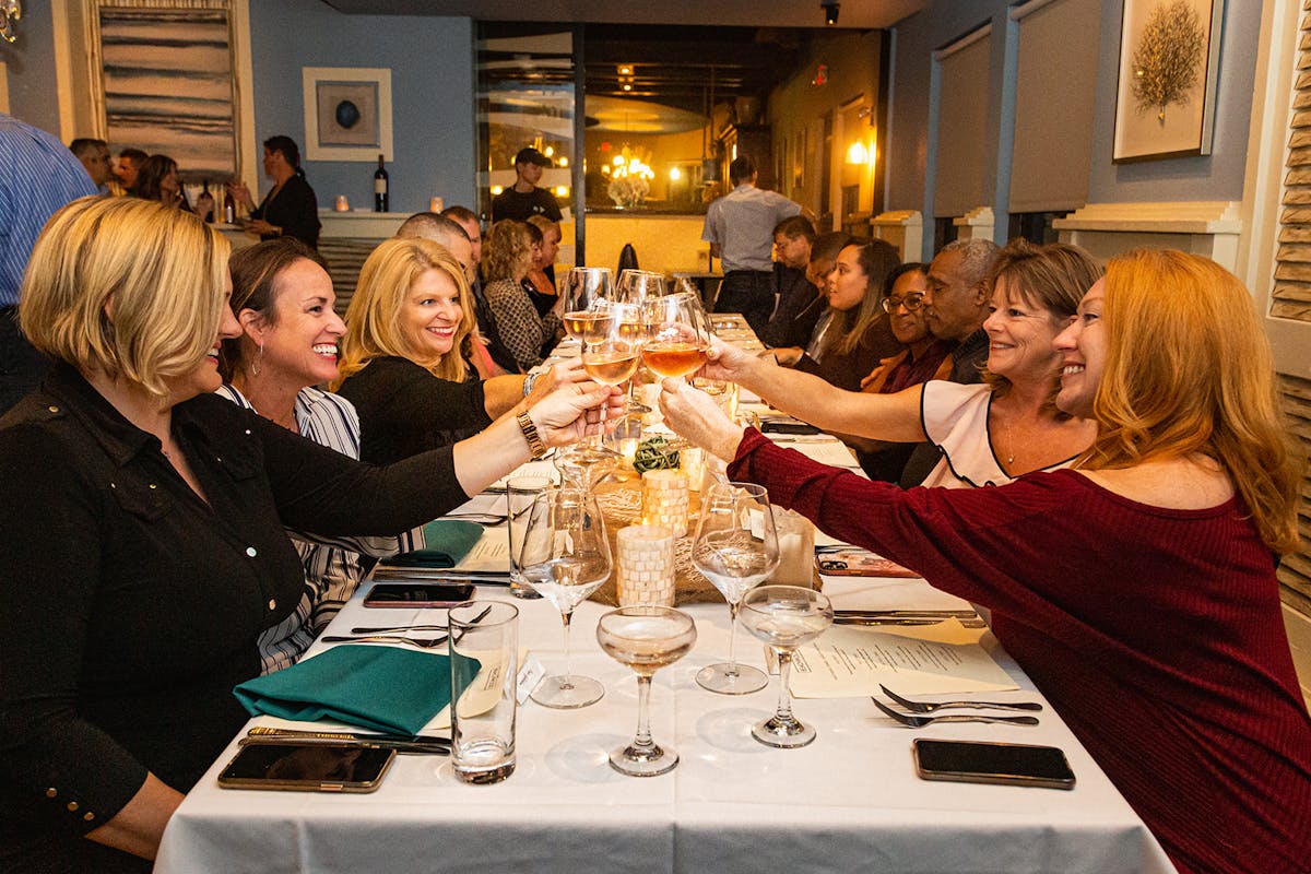 a group of people sitting at a table with wine glasses