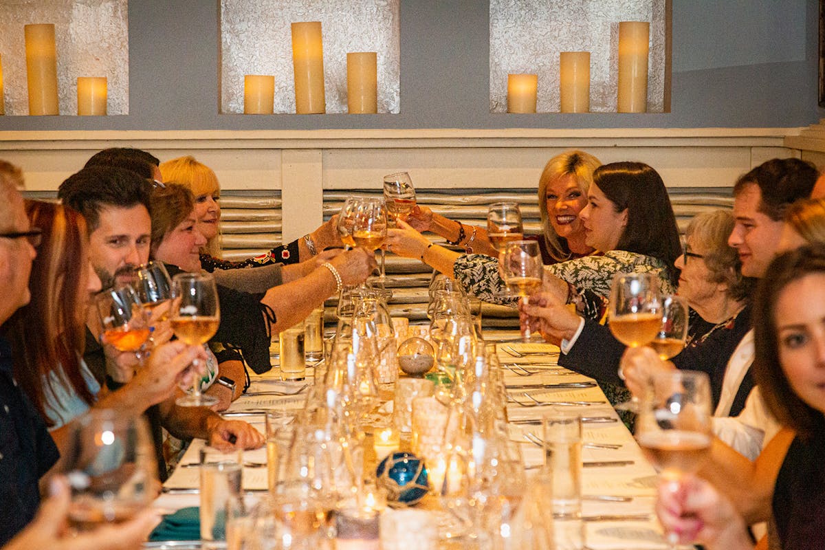 a group of people sitting at a table with wine glasses