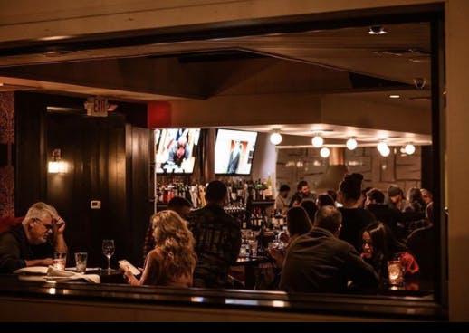 a group of people standing in front of a bar
