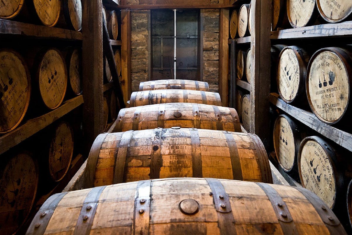 a wooden clock sitting in front of a barrel