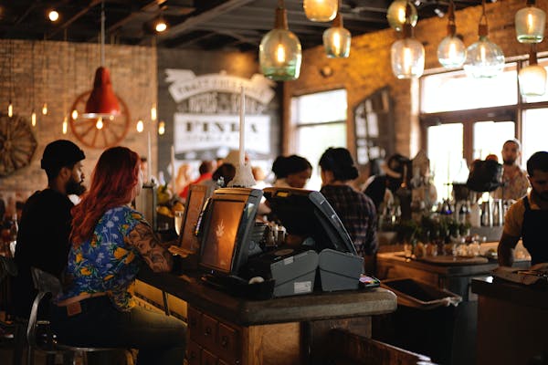 people working in a cafe filled with people