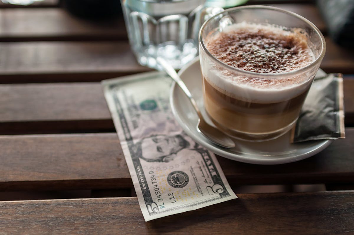 a cup of coffee sitting on top of a wooden table