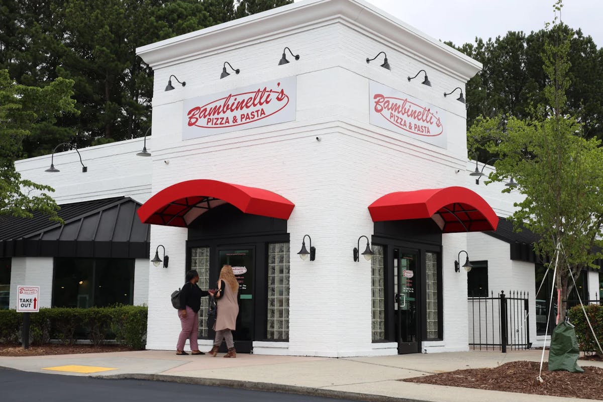 View of a restaurant with multiple cars parked outside, indicating a popular dining spot