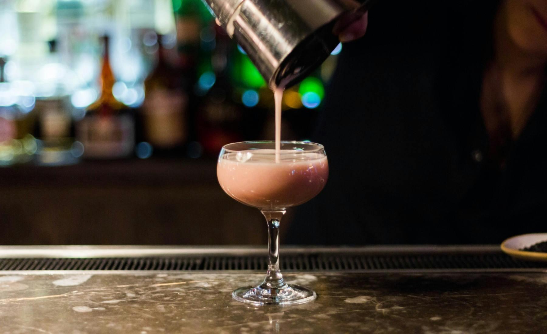 a cocktail being poured into a glass