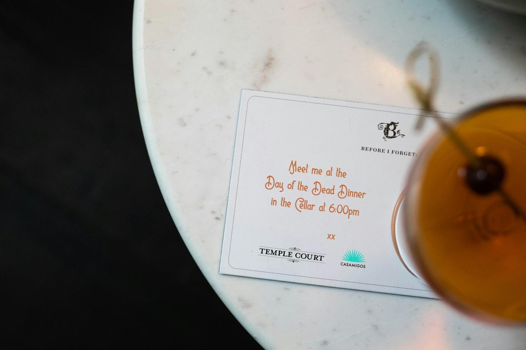 written invitation next to a cocktail
