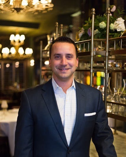 a man in a suit standing in front of a store