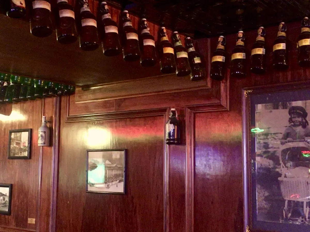 a restaurant wall with pictures and bottles 