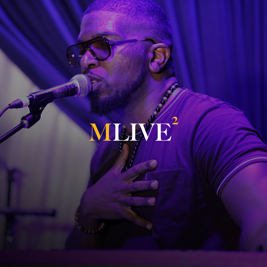 a man on a stage in front of a curtain