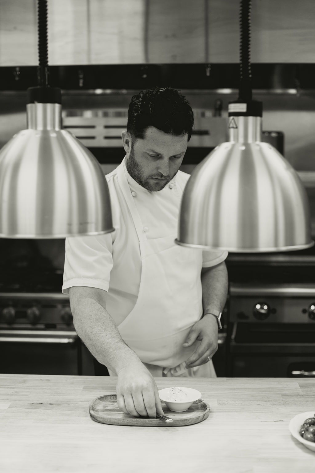 a man in a chef's uniform cutting food